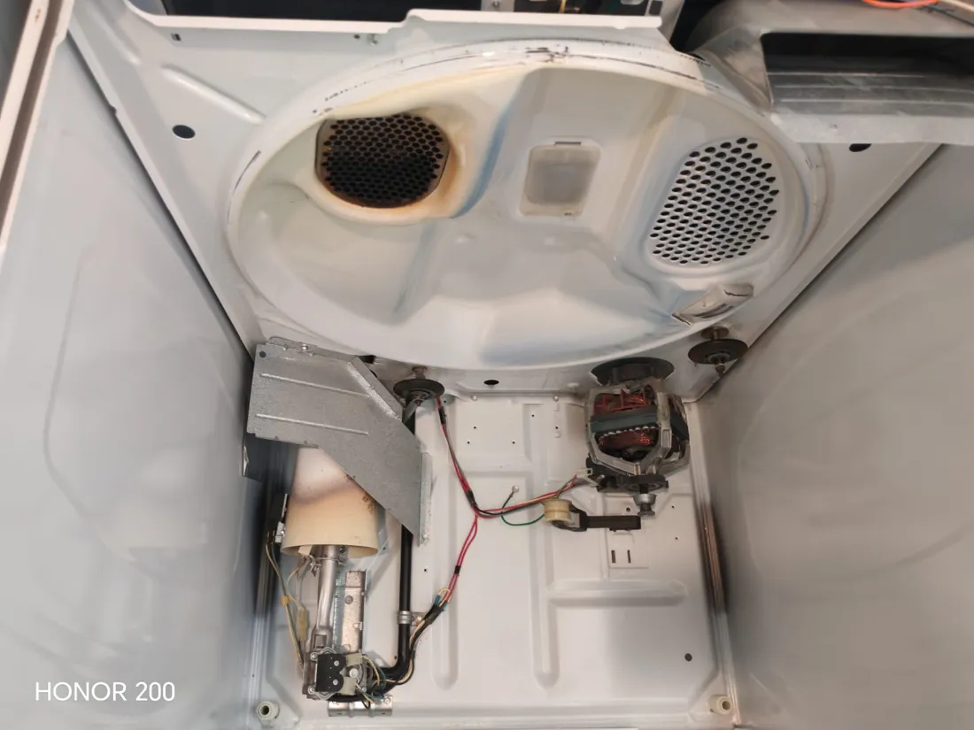 Reparación de secadora: interior del equipo con resistencia y motor expuestos